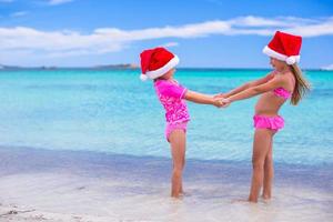 Little girls in Santa hats during summer vacation photo