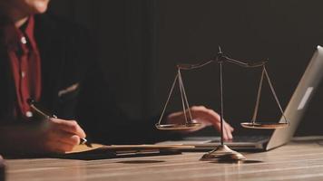 Business and lawyers discussing contract papers with brass scale on desk in office. Law, legal services, advice, justice and law concept picture with film grain effect video