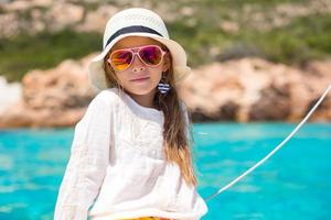 Little girl enjoying sailing on boat in the open sea photo