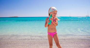 Little adorable girl in swimsuit with suntan lotion bottle photo