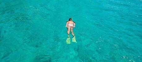 Beautiful girl snorkeling in clear tropical turquoise waters photo