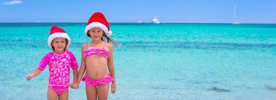 Little girls in Santa hats during summer vacation photo