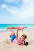 papá feliz y su pequeña hija en la playa tropical divirtiéndose foto