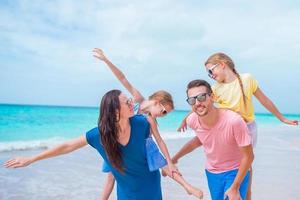 hermosa familia feliz en la playa blanca divirtiéndose foto