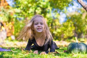 Happy little girl in halloween costume with jack pumpkin.Trick or treat photo