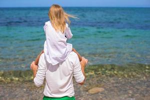 Happy father and adorable little daughter on the beach photo