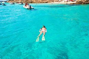 Young active girl snorkeling in tropical water on vacation photo