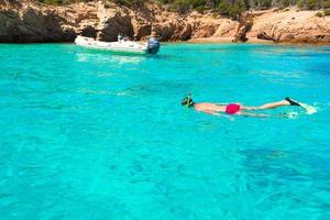 Young man snorkeling in clear tropical turquoise waters photo