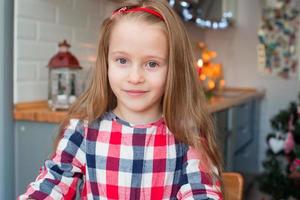 Portrait of little adorable girl baking Christmas cookies at home photo