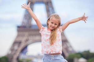 adorable niña en el fondo de parís la torre eiffel durante las vacaciones de verano foto