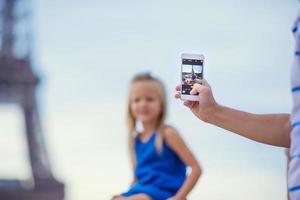 Cute little girl background the Eiffel tower during summer vacation in Paris photo