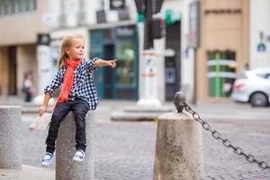 Adorable little girl at european city outdoors photo