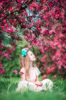 Adorable little girl in beautiful blooming apple garden outdoors photo