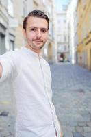 Young man background the old european city take selfie photo
