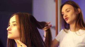 giovane capelli stilista rendere acconciatura con bellissimo donna a salone video