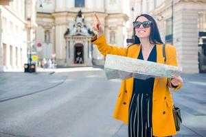 mujer joven con un mapa de la ciudad en la ciudad. chica turística de viaje con mapa en viena al aire libre durante las vacaciones en europa. foto
