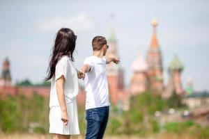 joven pareja enamorada caminando en el fondo de la ciudad iglesia de st basils foto