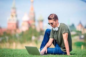 Man is working by laptop while relaxing in the park photo