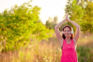 Young smiling woman doing sporty exercises outdoors photo