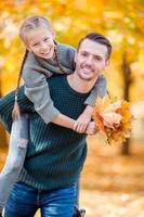 Family of dad and kid on beautiful autumn day in the park photo