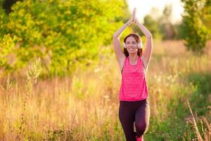 joven sonriente haciendo ejercicios deportivos al aire libre foto