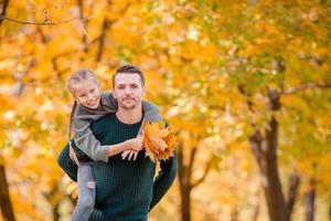 Family of dad and kid on beautiful autumn day in the park photo