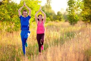 joven pareja sonriente haciendo ejercicios deportivos al aire libre foto
