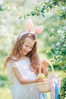 adorable niñita en un floreciente jardín de manzanas en un hermoso día de primavera