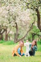 niñas sonrientes jugando y abrazando a un cachorro en el parque foto