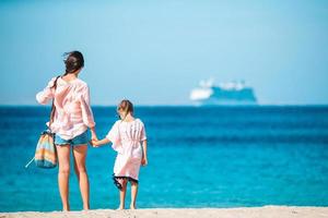 Beautiful mother and daughter at Caribbean beach enjoying summer vacation. photo