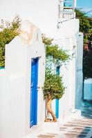 las estrechas calles de la isla con balcones azules, escaleras y flores en grecia. foto