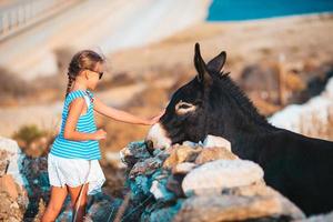 Little girl with donkey on the island of Mykonos photo