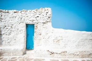 The narrow streets of the island with blue balconies, stairs and flowers in Greece. photo