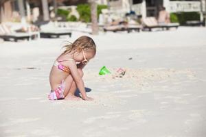 Adorable little girl in swimsuit at tropical carribean beach photo