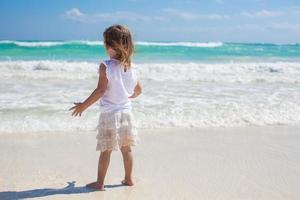 Adorable little girl on exotic white beach at sunny day photo