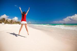 Young beautiful woman raises her arms up on the beach photo