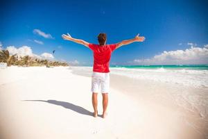 Back view of Young man enjoying the holiday on carribean beach photo