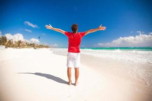 Back view of Young man enjoying the holiday on carribean beach photo