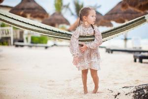 Adorable little girl on tropical vacation relaxing in hammock photo