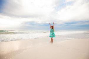 Little cute girl running on the white sandy beach in Mexico photo