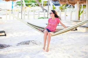 Young woman on tropical vacation relaxing in hammock photo