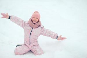 Portrait of little adorable girl in snow sunny winter day photo