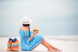 Young woman drinking coconut milk during tropical vacation photo