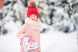 Cute little kid girl is going skate outdoors. photo