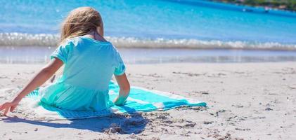 Adorable little girl have fun at tropical beach during vacation photo