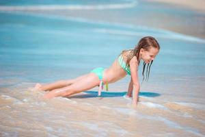 Adorable little girl at beach having a lot of fun in shallow water photo