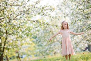 niña en el floreciente jardín de cerezos al aire libre en la víspera de Pascua foto