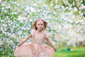 Cute girl in blooming apple tree garden enjoy the warm day photo