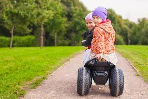 Portrait of little girls ride a motorbike outdoors photo