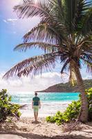 joven turista caminando hacia la isla caribeña foto